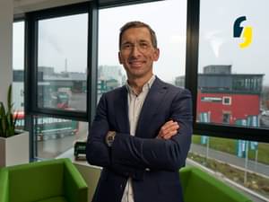 Bertram Scholtes, Managing Director of Knettenbrech and Gurdulic, stands at the window of his office. Company trucks are driving outside.