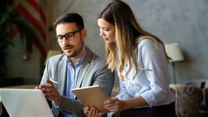Two engineers in a warehouse are talking