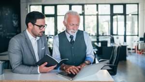 Junior- und Senior-Geschäftsmänner diskutieren über Arbeit