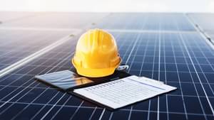 Abbildung zeigt einen gelben Helm und Dokumente auf einem Solarpannel