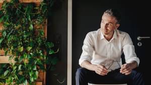 Geschäftsmann sitzt in einem grünen Büro. Nachhaltiges Banking.