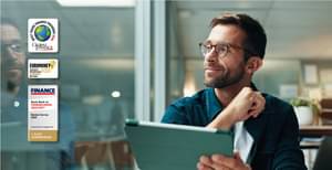 Businessman in the office with a tablet in hand, smiling and looking to the side.