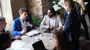 Geschäftsleute sitzen am Konferenztisch und diskutieren über eine nachhaltige Innovationsstrategie – Nachhaltigkeits- und Green-Economy-Konzept