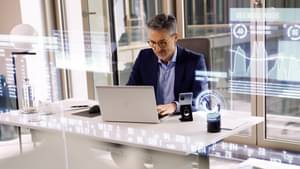Businessman at the desk checks his banking transactions on the laptop, digital banking.
