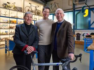The Lange family is standing together behind a bicycle in their bicycle shop
